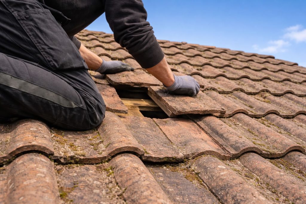 cost of roofing work - roofer repairing missing roof tile